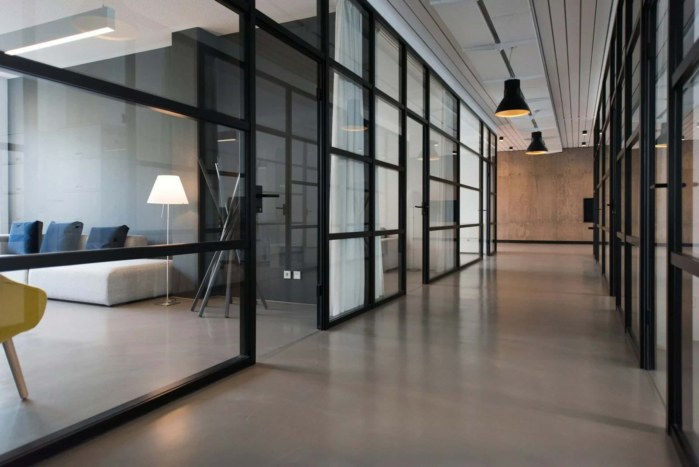 Cam bölmeli ofis koridoru ve koridorun sonundaki oturma alanı